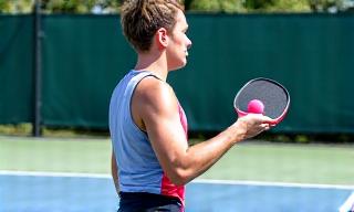 Pickleball player serving during a game